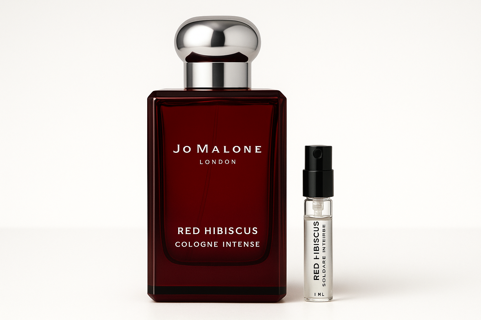 Amostra de 1ml de Jo Malone Red Hibiscus Cologne Intense ao lado de um frasco de perfume de 100ml de Jo Malone Red Hibiscus Cologne Intense com escrita branca no frasco vermelho escuro