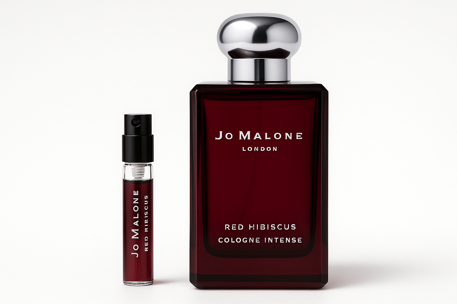 Amostra de Jo Malone Red Hibiscus Cologne Intense de 2 ml ao lado de um frasco de perfume de 100 ml de Jo Malone Red Hibiscus Cologne Intense com escrita branca no frasco vermelho escuro